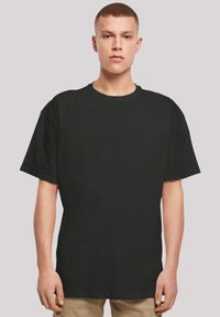 Black short-sleeve t-shirt featuring a round neckline, straight cut, and soft fabric texture. Designed for a relaxed fit.