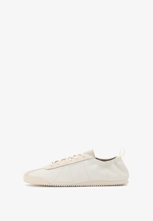 Zapatillas de cuero crema con puntera redondeada, diseño de cordones, acentos texturizados y suela de goma texturizada con patrón de tracción en zigzag.