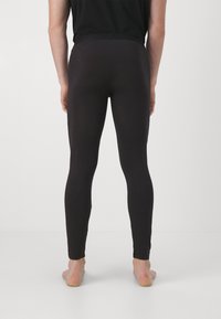 Black leggings made of stretch fabric, fitted design, smooth texture, full-length, with a wide waistband, and no visible hardware or patterns.