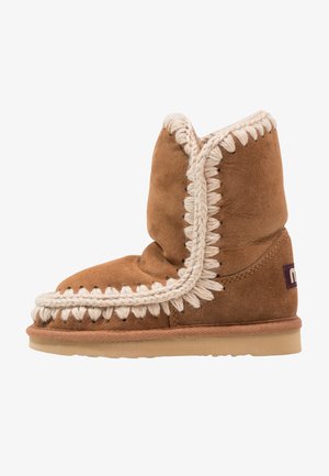 Stivale in camoscio marrone con una texture morbida, caratterizzato da un'elegante bordatura intrecciata in crema lungo il bordo e una suola piatta in gomma.