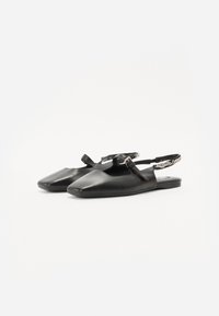 Pantofi slingback din piele neagră, cu vârf ascuțit, talpă plată și o curea decorativă. Textură netedă și design minimalist.