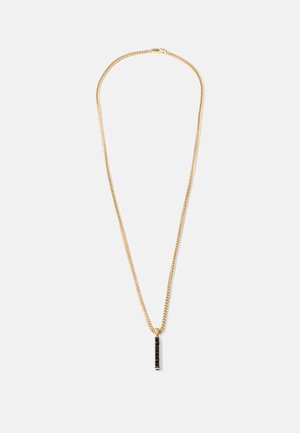 Gouden ketting met een verticale rechthoekige zwarte hanger met een gestructureerd oppervlak, weergegeven op een eenvoudige witte achtergrond.