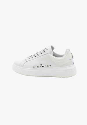 Białe sneakersy z teksturowaną skórzaną cholewką, okrągłym noskiem i płaskimi sznurowadłami. Posiadają czarne logo z boku oraz masywną białą podeszwę.