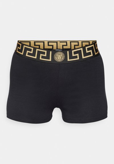 Black boxer shorts with a contrasting gold waistband featuring a Greek key pattern and a central logo medallion. Soft, stretchy material.
