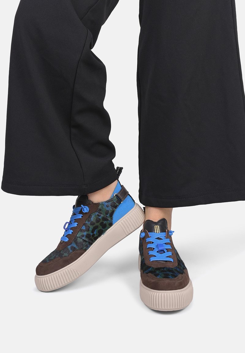 Sneaker marrone e blu con stampa leopardata, tomaia in suede e tessuto, suola testurizzata, lacci blu e un tab retro per facilitare l'indossamento.