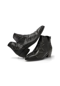 Botines de piel negra con puntera afilada, tacones bajos, patrón de serpiente en relieve y tachuelas plateadas decorativas en un estilo occidental.