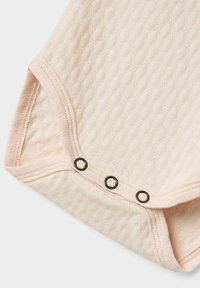 Bodysuit rose clair avec motif de diamants texturé, doté d'une fermeture à pressions en bas et de pressions en métal noir contrastantes.