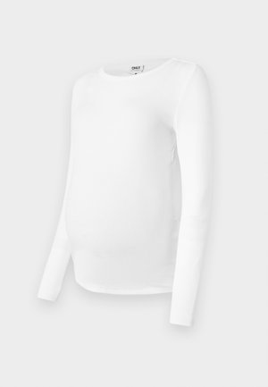 Bala garām piedurknēm grūtniecei paredzēta blūze, izgatavota no ribota auduma, ar noapaļotu kakla izgriezumu un pieguļošu piegriezumu, lai pielāgotos augošajai vēderi.