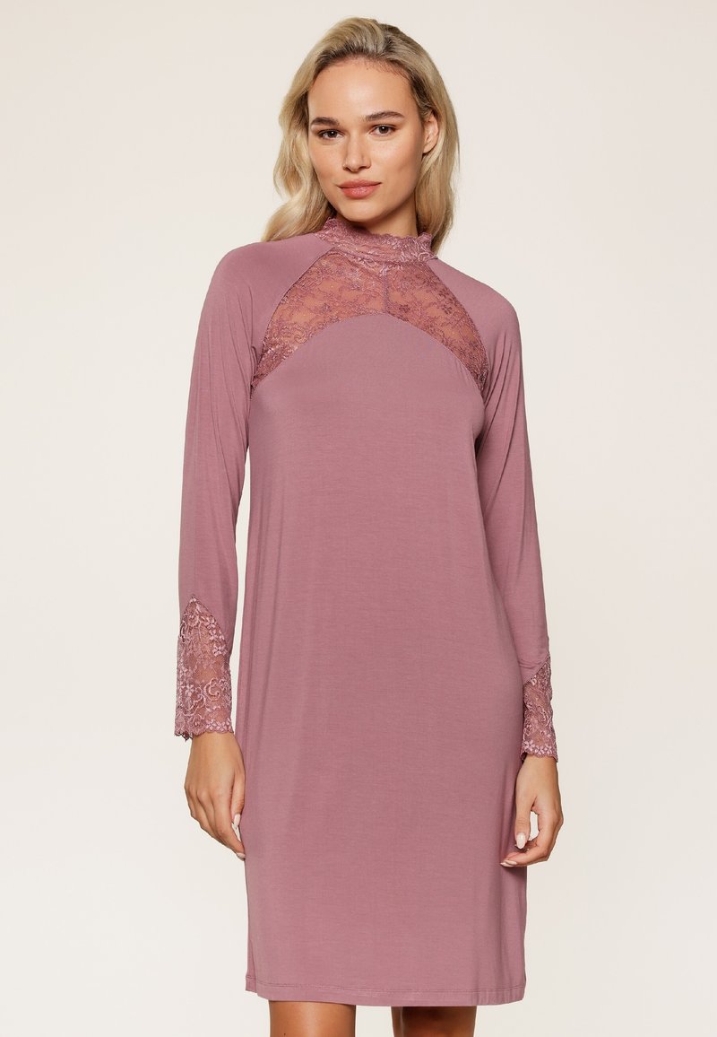 Robe à manches longues mauve avec un panneau en dentelle sur la poitrine et des accents en dentelle aux poignets des manches. Tissu doux avec une coupe décontractée.