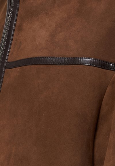 Pruun suedi jakk, millel on siledast nahast aktsent. Kujunduses on täispikk lukk ja horisontaalne nahast triip ees.