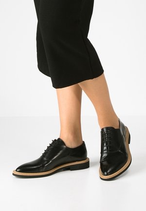 Zwarte leren oxford schoenen met een ronde neus, veterontwerp en contrasterende beige zool. Glad oppervlak met gepolijste afwerking en zachte voering.