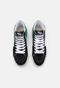 Vysoké tenisky s černými semišovými svrškami, bílými tkaničkami a tyrkysově vzorovanou látkou na zadní straně. Bílé gumové podrážky s kontrastním švem.