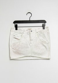 Vit jeanskjol i mini-stil med framfickor och bältesöggor hängande på svart klädhängare mot en enfärgad bakgrund.