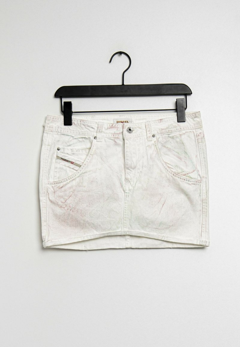 Vit jeanskjol i mini-stil med framfickor och bältesöggor hängande på svart klädhängare mot en enfärgad bakgrund.