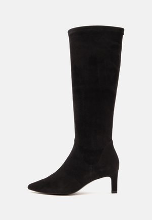 Black knee-high suede boot with pointed toe and slim mid-height heel shown from the side on white background.