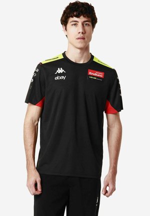 Maglietta atletica nera con maniche corte, dettagli verdi e rossi, con loghi degli sponsor sul petto e sulle maniche, realizzata in tessuto traspirante.