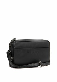 Borsa a spalla in pelle nera con forma rettangolare, finitura testurizzata, chiusura con zip e tracolla regolabile. Presenta un logo sul davanti.