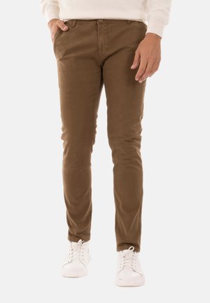 Pantaloni chino in cotone marroni con vestibilità slim, dotati di tasche anteriori e una texture liscia, abbinati a sneakers bianche.