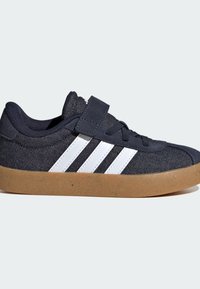 Tmavě modré textilní tenisky s bílými pruhy a gumovou podrážkou. Mají suchý zip a tkaničkové zavazování pro bezpečné upevnění.