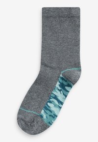 Graue Socke mit strukturiertem Strick, die ein türkisfarbenes Camouflage-Muster am Knöchel aufweist. Akzentuiert mit einem hellblauen Streifen nahe der Oberseite.