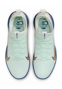 Scarpe da ginnastica verde chiaro con tomaia texturizzata, logo swoosh arancione e suola blu. Presentano lacci e una linguetta sul tallone.