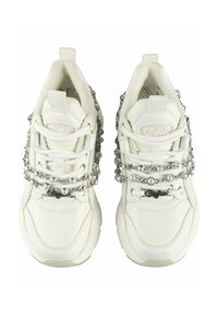 White sneakers with a textured finish, accented by silver and pearl chains across the laces, featuring a logo patch on the side.