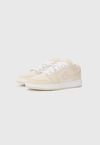Beez Nike'i tossud valgete paeltega, sileda nahaga, tagasihoidlike oranžide aktsentidega, ümmarguse varbaga ja tekstuurse kummitaldaga.