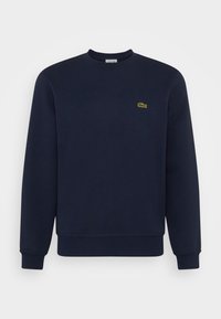 Námořnická modrá mikina z bavlněné směsi, s kruhovým výstřihem, na hrudi malá zelená vyšitá značka krokodýla, žebrované manžety a lem.