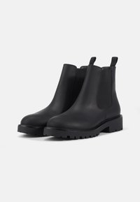 Zwarte leren Chelsea boots met elastische zijpanelen, een ronde neus en een chunky rubberen zool met een nauwkeurig grippatroon.