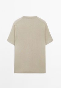 Beige tričko s krátkým rukávem, s kulatým výstřihem, vyrobené z měkké látky, s hladkým povrchem bez vzorů či akcentů. Zobrazeno ze zadní strany.
