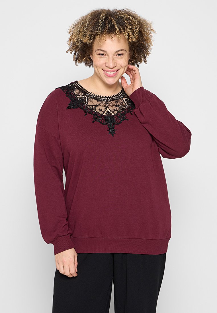 Maglione bordeaux con maniche lunghe, dettagli in pizzo all'collo e vestibilità comoda. Tessuto morbido con polsini e orlo a costine.