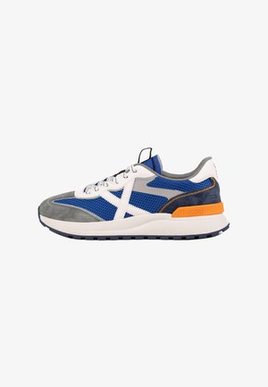 Sneaker mit einem blauen Mesh-Obermaterial, grauen und weißen Wildlederakzenten, kontrastierenden orangefarbenen Beschlägen und einer dicken weißen Sohle mit schwarzer Profilsohle.