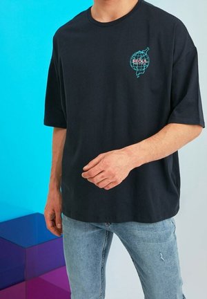 Black cotton t-shirt with a round neck and short sleeves. Features a teal globe graphic with "SEOUL" text on the front. Casual fit.