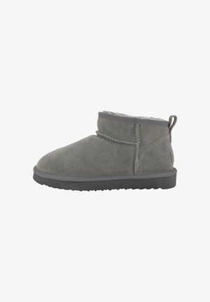 Graue Wildleder Stiefeletten mit einer runden Zehenpartie, weicher Innensohle, kleinem Absatz und Zuglasche auf der Rückseite. Die Sohlen sind strukturiert für besseren Halt.