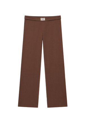 Brązowe spodnie z szerokimi nogawkami, z podwiniętym pasem i małą białą metką z logo umieszczoną centralnie z przodu.
