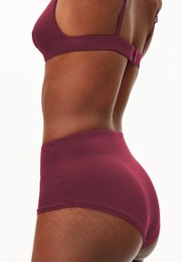 Bordeaux hoge taille brief van soepel materiaal, met een brede elastische tailleband en naadloze randen voor comfort. Minimalistisch ontwerp zonder patronen.