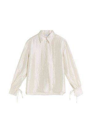 Elfenben, långärmad skjorta med en något glansig yta, knäppning fram och snören vid ärmarna. Har klassisk krage och avslappnad passform.