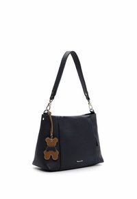 Czarna skórzana torebka o fakturowanej powierzchni, z odczepianym brązowym breloczkiem w kształcie misia oraz pojedynczym paskiem na ramię.