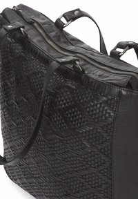 Zwarte leren schoudertas met een gevlochten textuur aan de ene kant, een gladde afwerking aan de andere kant, dubbele bovenhandvatten en een ritsluiting.