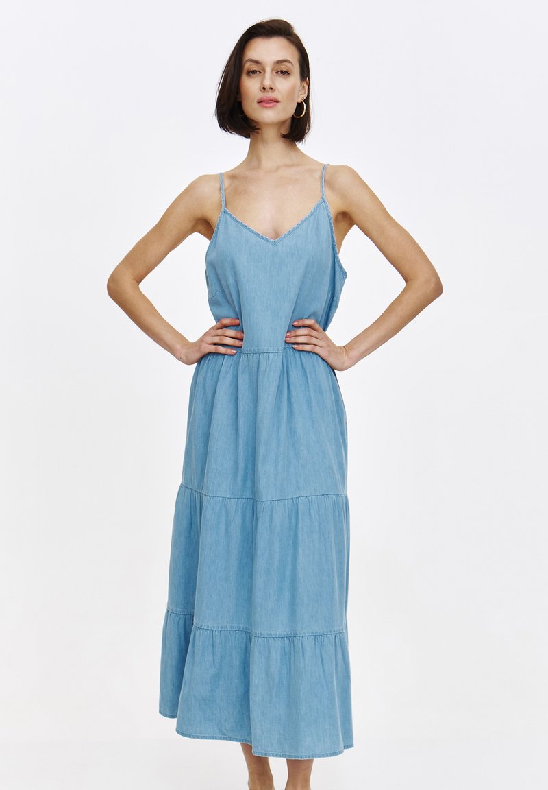 Hellblaues, gestuftes Denim-Kleid mit verstellbaren Spaghetti-Trägern, V-Ausschnitt und geraffter Taille. Weicher Stoff mit fließendem Design.