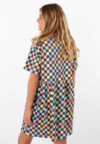 Robe à manches courtes avec un motif à damier en couleurs pastel sur fond noir. Coupe ample avec une taille froncée et des poches.