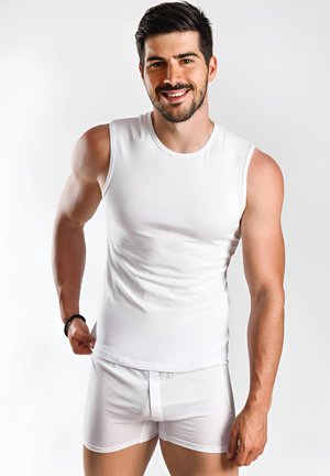 Weißes ärmelloses Shirt und weiße Boxerbriefs, aus glattem Stoff. Das Shirt hat einen runden Ausschnitt, eine körpernahe Passform und minimale Nähte.