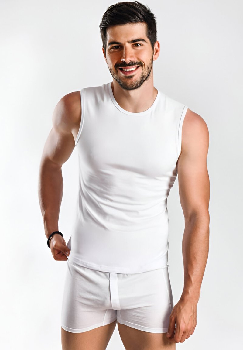 Witte mouwloze shirt en witte boxershorts, gemaakt van een zachte stof. Het shirt heeft een ronde halslijn, een slim fit ontwerp en minimale naden.