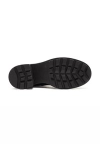 Black rubber shoe sole with a textured tread pattern, designed for grip and durability. Smooth central section flanked by pronounced grooves.