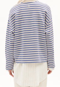 Wygodna bluzka z długim rękawem w kremowo-niebieskie paski, o luźnym kroju, z prążkowanym dekoltem oraz logo z tyłu. Gładka tkanina o miękkiej fakturze.