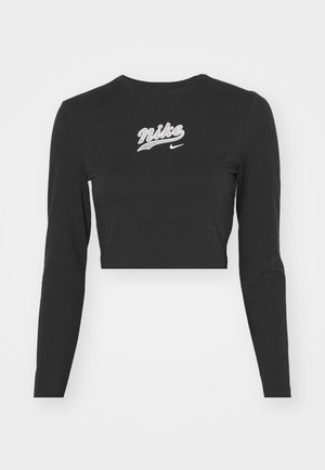 Czarny długi rękaw crop top wykonany z bawełny, z białym haftowanym logo "Nike" i swooshem na klatce piersiowej, okrągłym dekoltem oraz dopasowanym krojem.