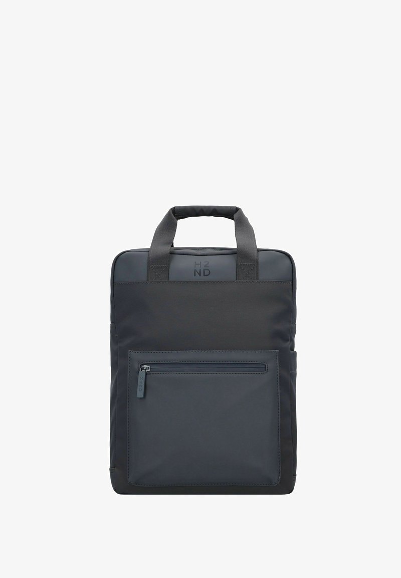 Zaino in nylon nero con doppie maniglie superiori, tasca frontale con zip e superficie liscia. Logo sottile sopra la tasca in grigio scuro. Forma rettangolare.