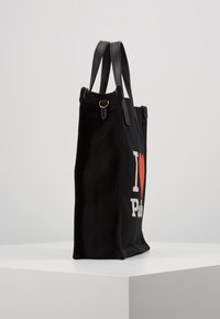 Černá plátěná taška s koženými popruhy má vyšitý nápis "Miluji Paříž" v bílé a červené barvě. Elegantní tvar s pevným designem a texturovanou tkaninou.