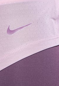 Nike sportsbh med en lys pink overdel med perforeret tekstur og en mørk lilla underdel. Logo i matchende pink foran.