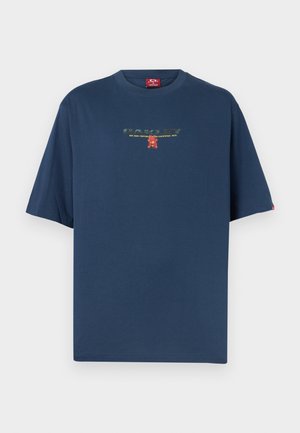 Temno modra majica s kratkimi rokavi z majhnim tiskanjem besedila in rdeče-rumeno grafiko na sredini prsnega koša.